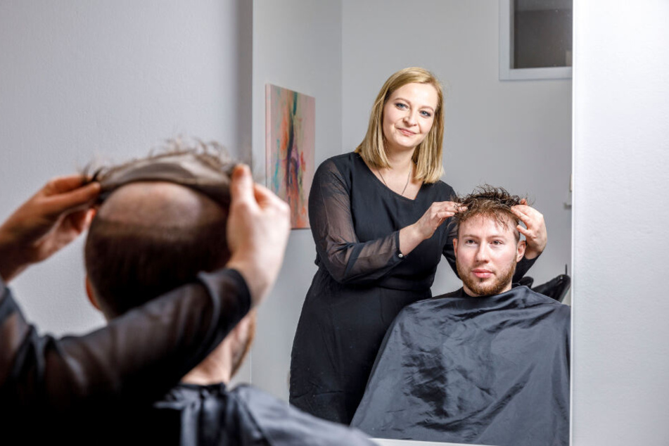 Behutsam befestigt Grit Bentzin (36) das Haarsystem auf dem Kopf ihres Kunden.