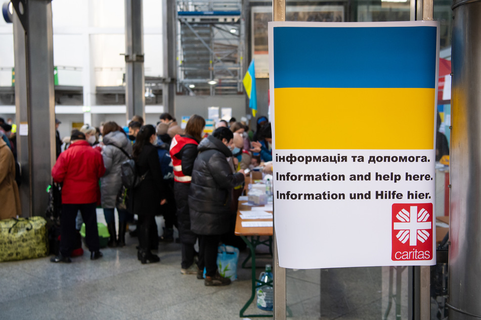 Flüchtlinge aus der Ukraine werden nach ihrer Ankunft am Hauptbahnhof von Mitarbeitern der Caritas und freiwilligen Helfern empfangen.