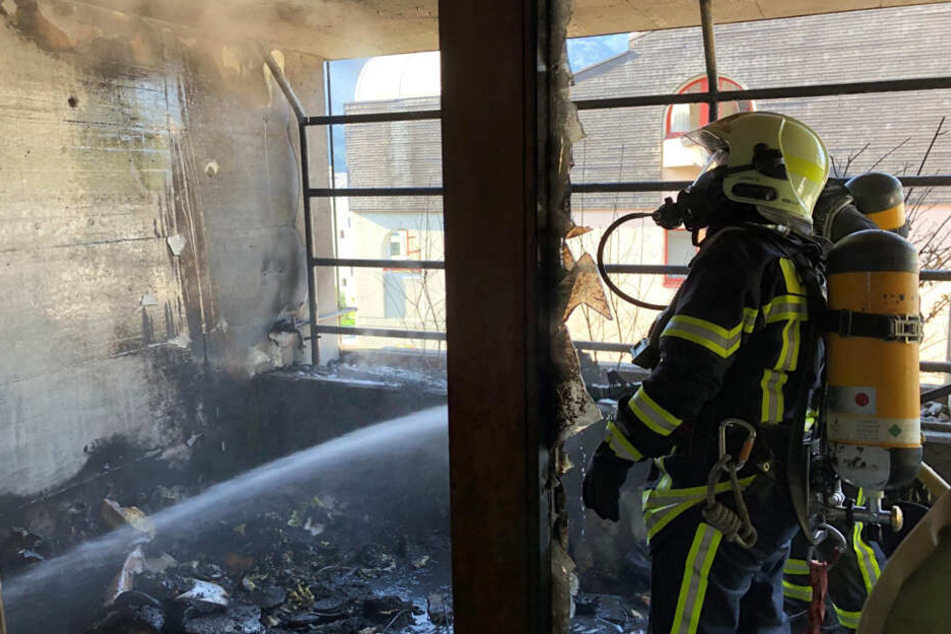Die Feuerwehr löscht die schwer beschädigte Wohnung.