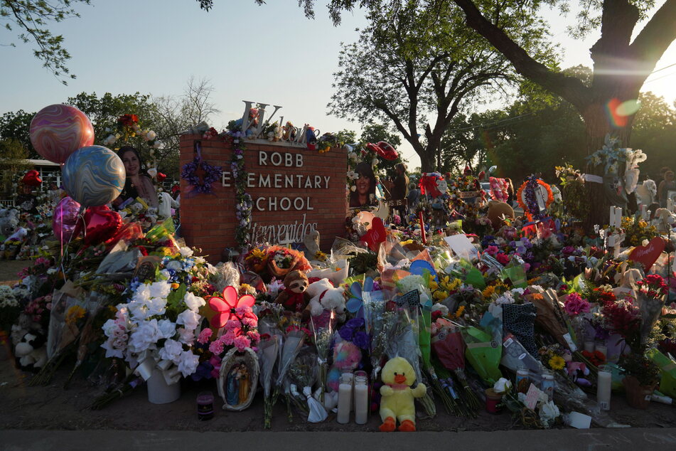 Flowers, toys, and other objects are placed to remember the victims of the mass shooting at Robb Elementary School.
