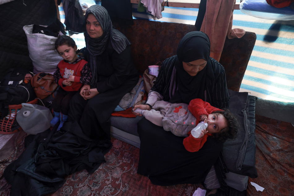 Displaced Palestinian women take care of their children inside a tent in Rafah in the southern Gaza Strip on Thursday.
