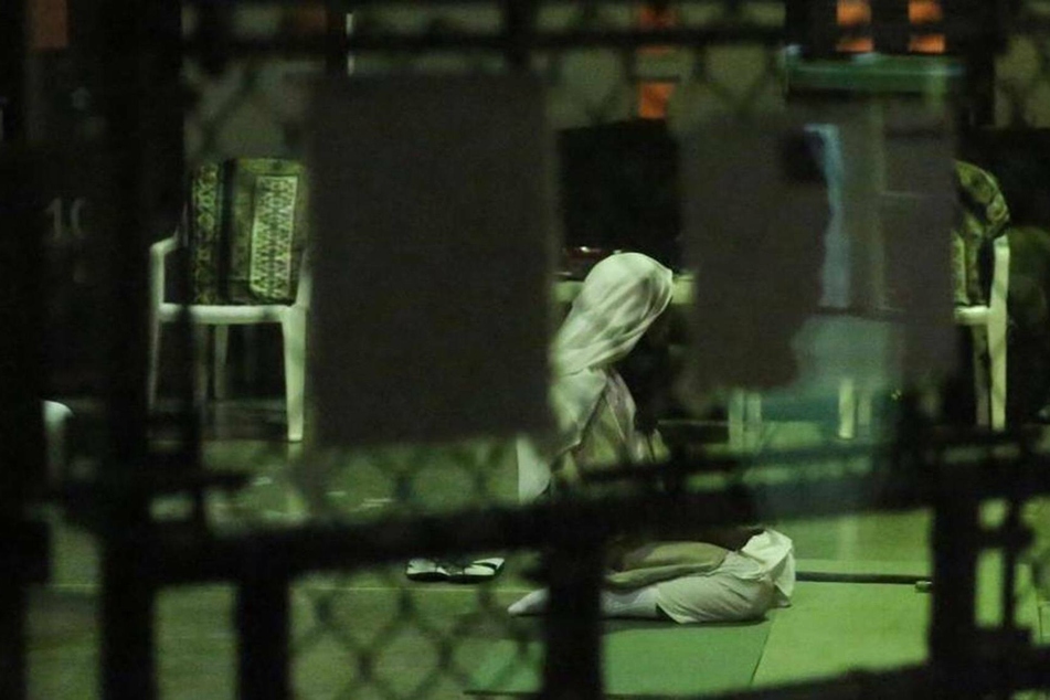 A detainee kneels in prayer at sunset at the Guantánamo Bay prison.