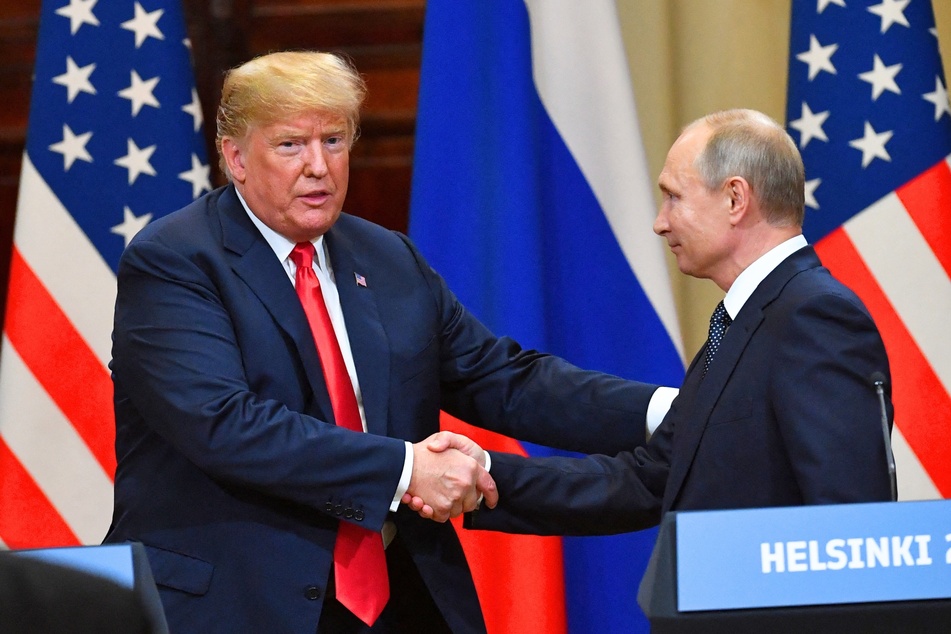 Donald Trump shaking hands with Russia's President Vladimir Putin at the end of a joint press conference after a meeting at the Presidential Palace in Helsinki, on July 16, 2018.