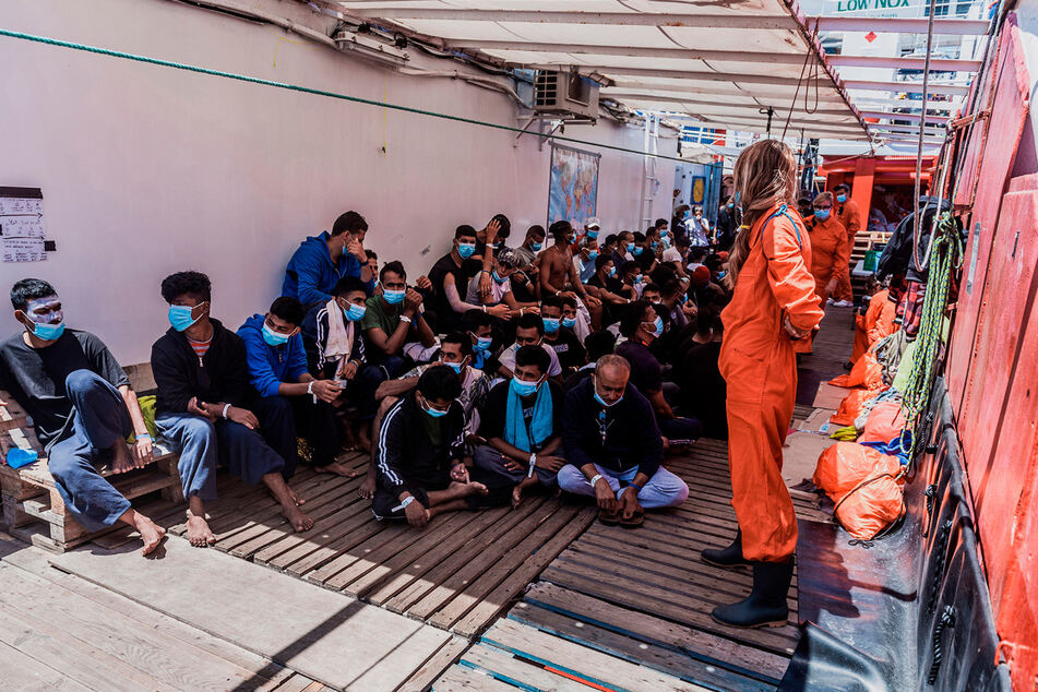 Migranten sitzen an Deck des privaten Rettungsschiffs "Ocean Viking". Italien hat die 180 Migranten auf dem Rettungsschiff auf das Coronavirus testen lassen und plant ihre Übernahme auf ein Quarantäneschiff.