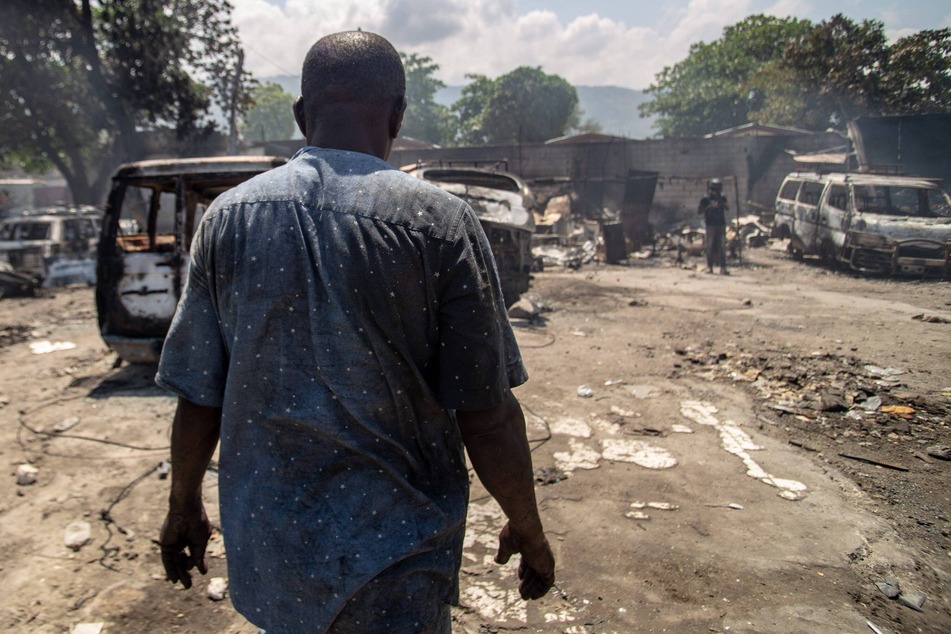 A garage manager in Port-au-Prince, Haiti, inspects the damage after gang members attacked and set fire to the facility.