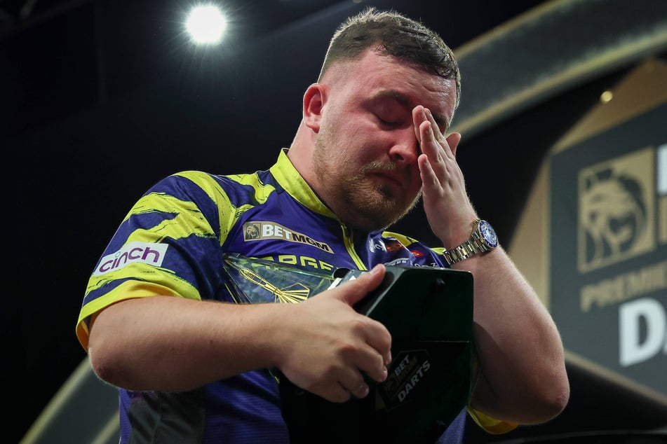 Noch mit der Trophäe der Premier League Darts in der Hand übermannten Luke Littler (19) die Tränen.