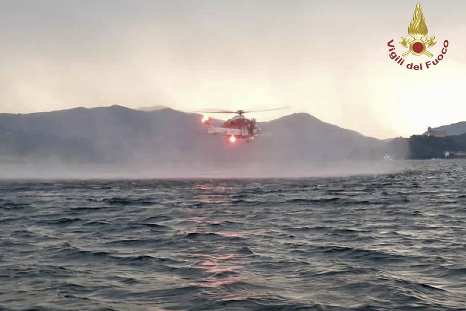 Dieses von der italienischen Feuerwehr veröffentlichten Bild zeigt einen Hubschrauber bei der Suche nach Vermissten, nachdem ein Touristen-Boot in einem Sturm auf dem italienischen Lago Maggiore gekentert ist.