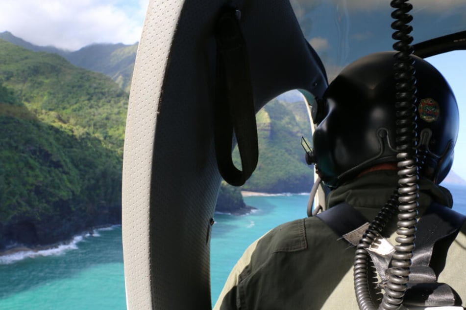 Das vom Hawaii Department of Land and Natural Resources zur Verfügung gestellte Foto zeigt ein Such- und Rettungsteam der Küstenwache, das über dem Napali Coast State Wilderness Park, auf Kauai, nach einem vermissten Ausflugshubschrauber sucht.