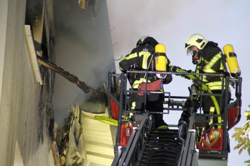 Feuerwehrleute löschten den Brand durchs Fenster im vierten Stock.