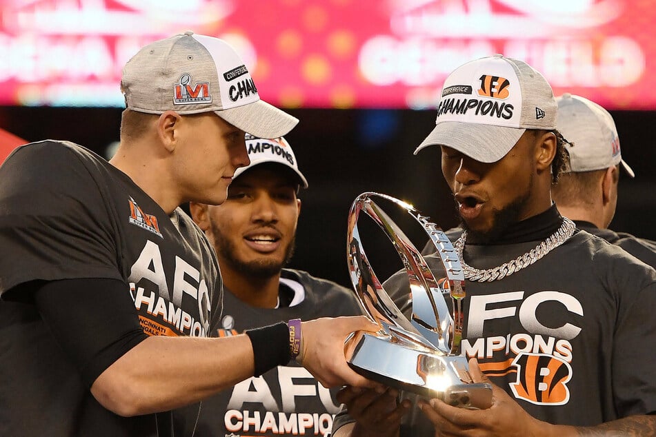 Cincinnati Bengals quarterback Joe Burrow (l.) with the Lamar Hunt trophy during the post-game celebrations.