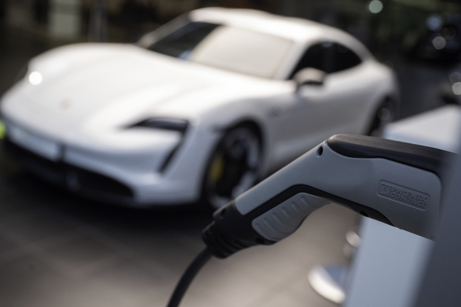 Ein elektrischer Porsche Taycan Turbo S steht im Porsche Zentrum Stuttgart hinter einer angedeuteten Ladesäule. Der Sportwagenbauer will zusammen mit einem Partner im kleinen Umfang Hochleistungs-Batteriezellen herstellen.