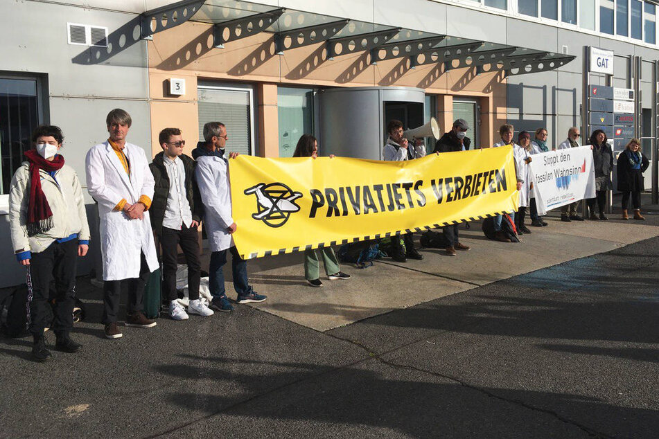 Mehrere Wissenschaftler und Klimaaktivisten blockieren das Terminal für Privatjets am BER.