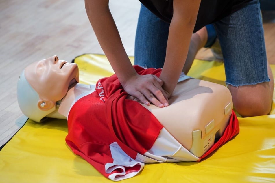 Ein Schüler trainiert eine Herzdruckmassage an einer speziellen Übungspuppe.