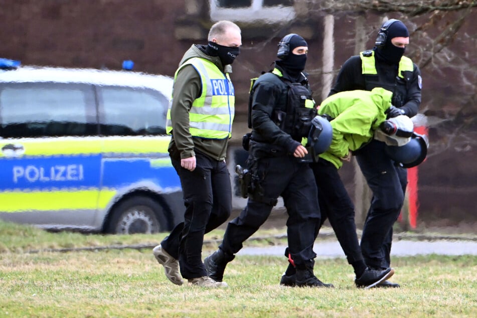 Schwer bewaffnete Polizisten bringen den Tatverdächtigen nach Karlsruhe.