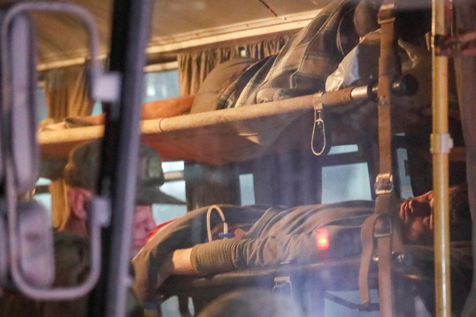 Wounded Ukrainian service members from the besieged Azovstal steel mill in Mariupol lie on stretchers in a bus, which arrived in Novoazovsk.