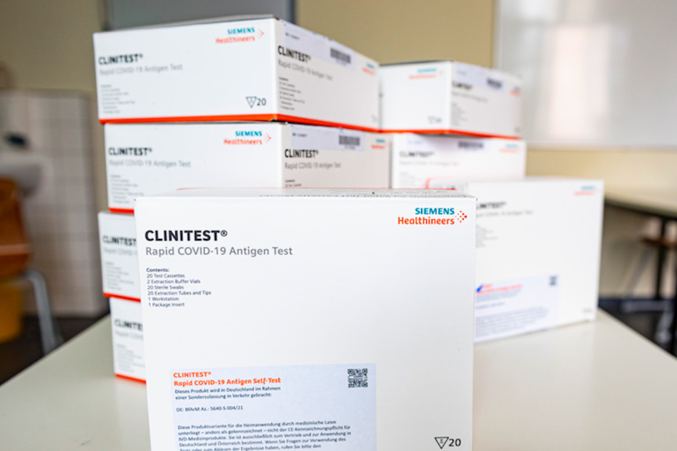 Ein Stapel Covid-19-Schnelltests "Clinitest Rapid COVID-19 Antigen Test" von Siemens Healthineers liegt auf einem Tisch in einer Schule.