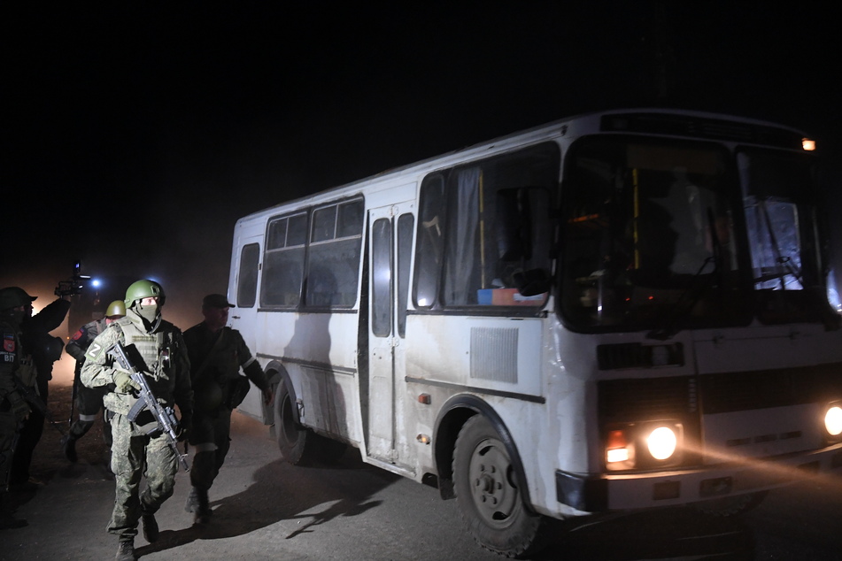 Soldaten der sogenannten Volksrepublik Donezk begleiten einen Bus mit verwundeten ukrainischen Soldaten aus dem Asow-Stahlwerk in Mariupol. Zahlreiche ukrainische Soldaten gerieten in Kriegsgefangenschaft.