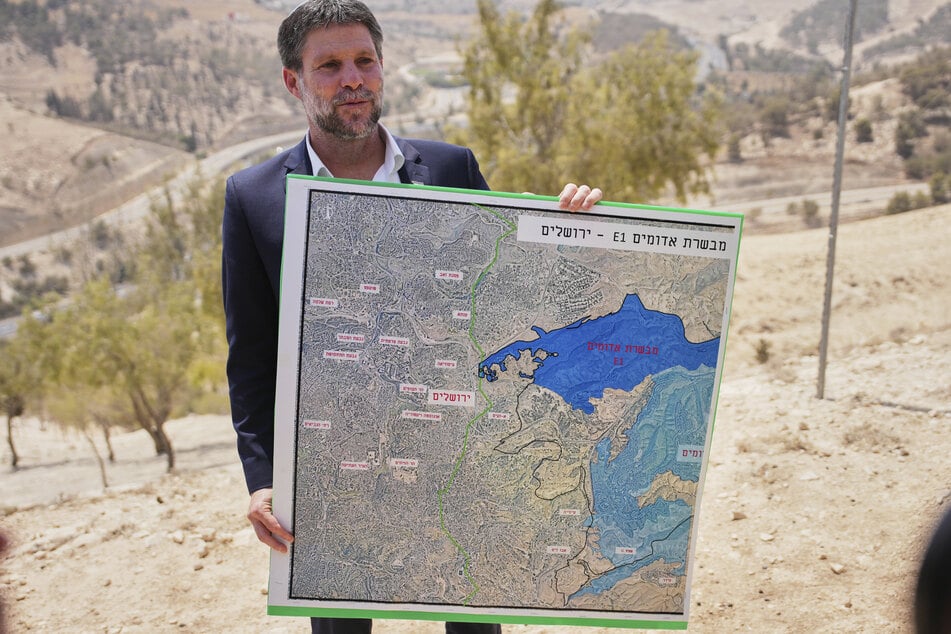 Der israelische Finanzminister Bezalel Smotrich hält während einer Pressekonferenz in der Nähe der Siedlung Maale Adumim im israelisch besetzten Westjordanland eine Karte, auf der das Siedlungsprojekt E1 dargestellt ist.