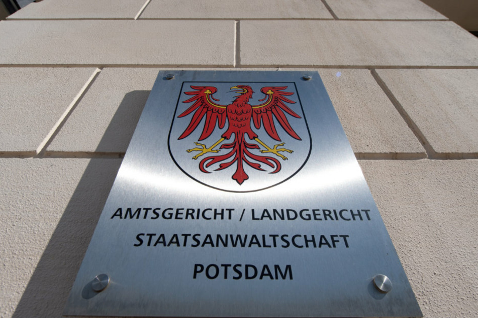 Das Metallschild neben dem Eingang zum Justizzentrum mit dem Roten Adler als Landeswappen und dem Verweis auf Amtsgericht, Landgericht und Staatsanwaltschaft.