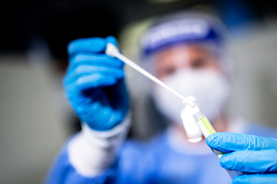 Eine Frau hält in einem Covid-19 Testcenter die Probe von einem Rachenabstrich in den Händen. Am Freitag kamen in Hamburg 160 Neuinfektionen hinzu. (Symbolfoto)