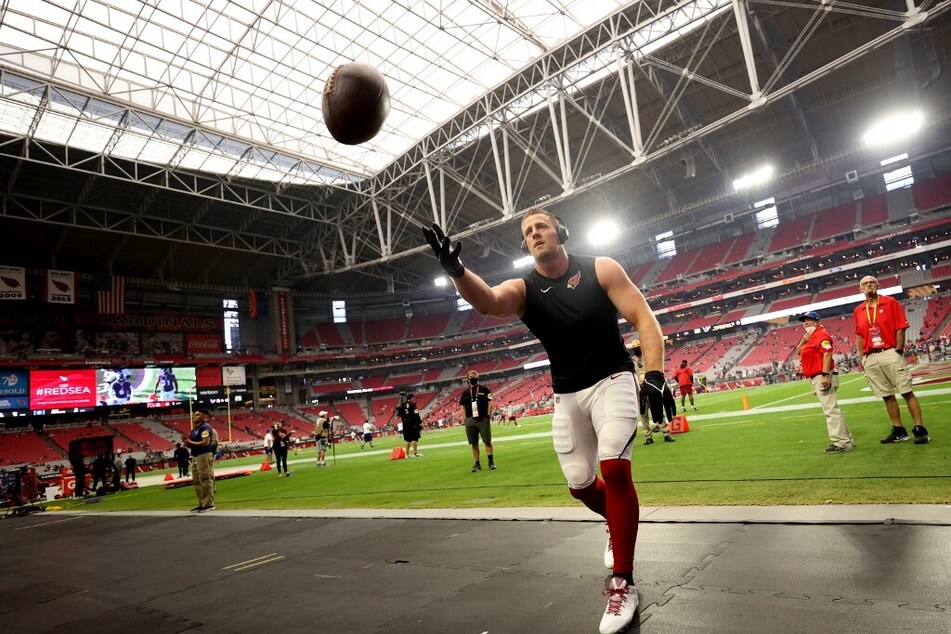 J.J. Watt of the Arizona Cardinals plays catch with fans before a game against the Houston Texans at State Farm Stadium.