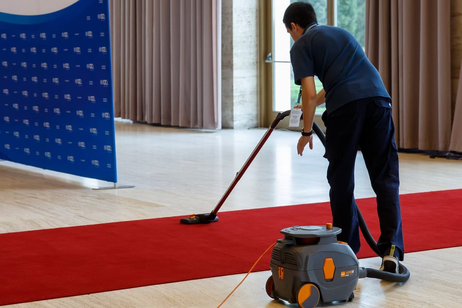 Ein Arbeiter in Genf reinigt den roten Teppich, bevor Staatsoberhäupter zu einer Konferenz im europäischen Hauptsitz der Vereinten Nationen kommen.