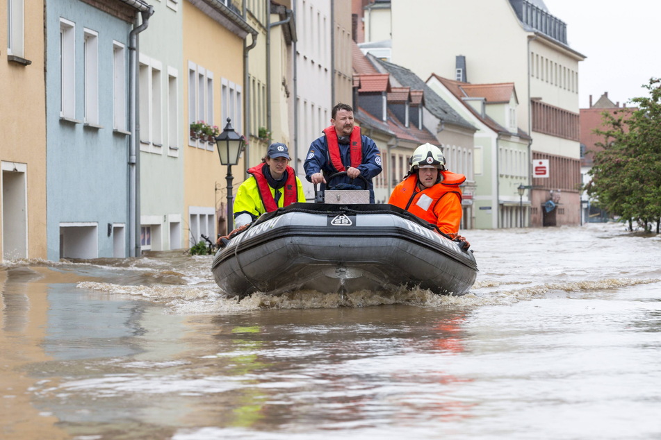 Helfer fahren im Juni 2013 mit einem Boot durch die überflutete Innenstadt. Freistaat und EU gaben insgesamt über 60 Millionen Euro für den Hochwasserschutz in der Stadt.