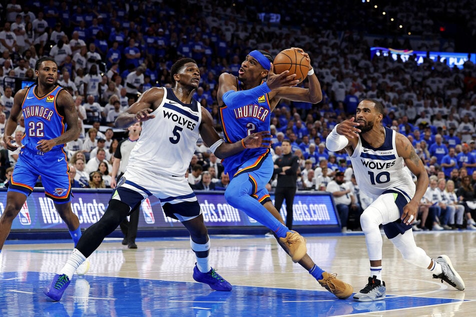 Oklahoma City Thunder guard Shai Gilgeous-Alexander drives to the basket against Minnesota Timberwolves guard Anthony Edwards and guard Mike Conley during the fourth quarter in Game Five of the NBA Western Conference Finals.