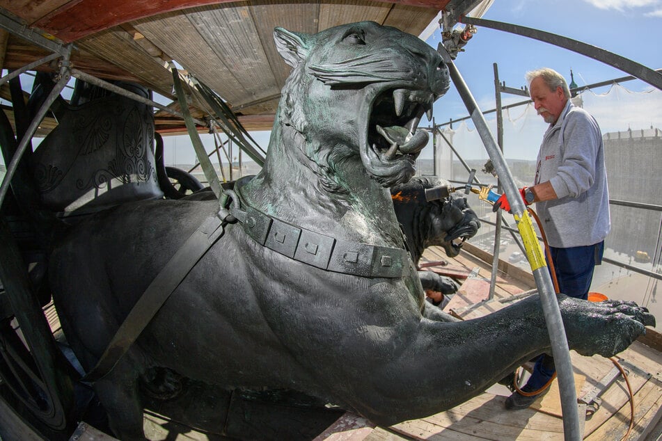 Andreas Kunze, Metallrestaurator der Firma Fuchs und Girke, bearbeitet die Panther der Quadriga auf der Semperoper mit Heißwachs.