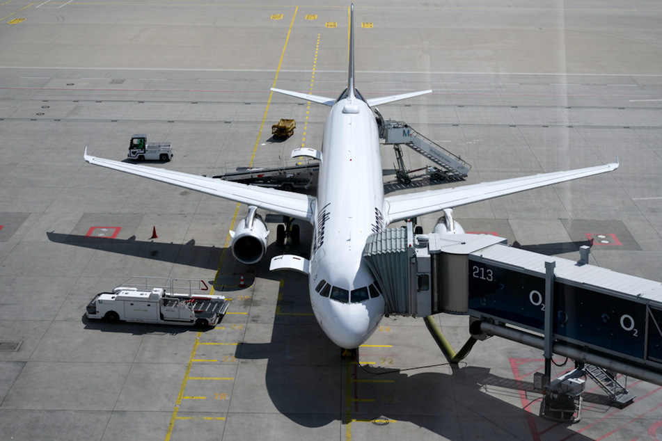 Ein Lufthansa-Flugzeug steht in München an einem Gate. Bis 2026 müssen in Deutschland mindestens 0,5 Prozent der Flugkraftstoffe aus synthetischem Kerosin bestehen.