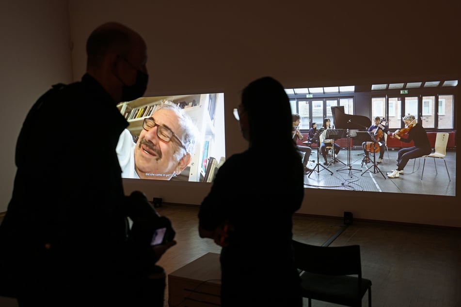 Ausstellungsbesucher stehen vor Boaz Kaizmans Videoinstallation über das jüdische Leben in Deutschland.