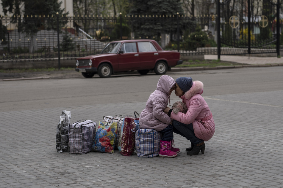 Um sich in Sicherheit vor dem russischen Angriffskrieg zu bringen, flüchten viele Menschen innerhalb oder aus der Ukraine - so wie diese Mutter, die ihre Tochter umarmt, während sie auf einen Bus warten, um aus der Stadt Slowjansk im Bezirk Donezk nach Riwne im Nordwesten der Ukraine zu fliehen.