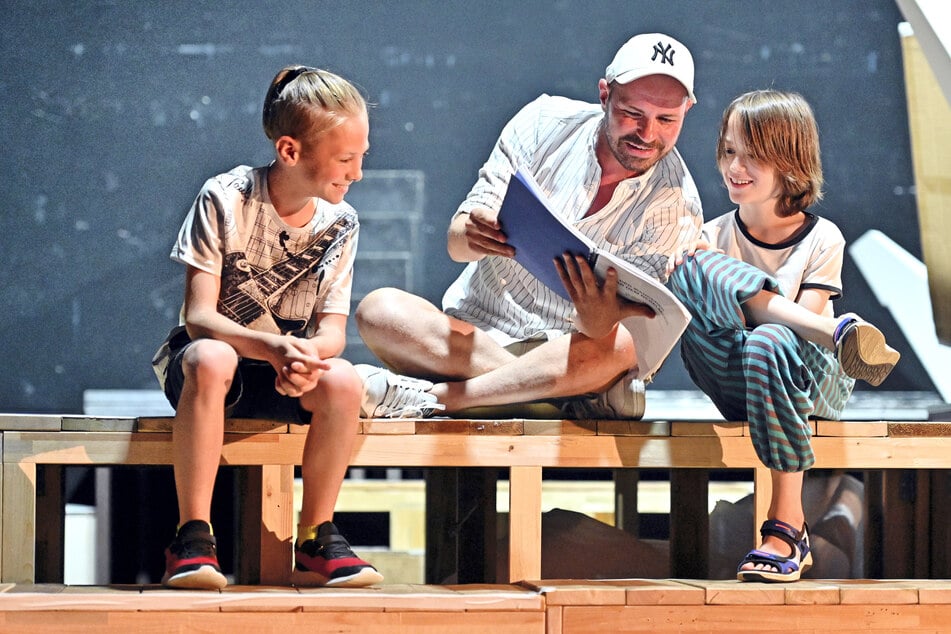 Regisseur Christian Kühn (43, M.) geht mit Levy Müller (12, l.) und Julius Krauße (10) die Szenen noch einmal mit dem Textbuch durch.
