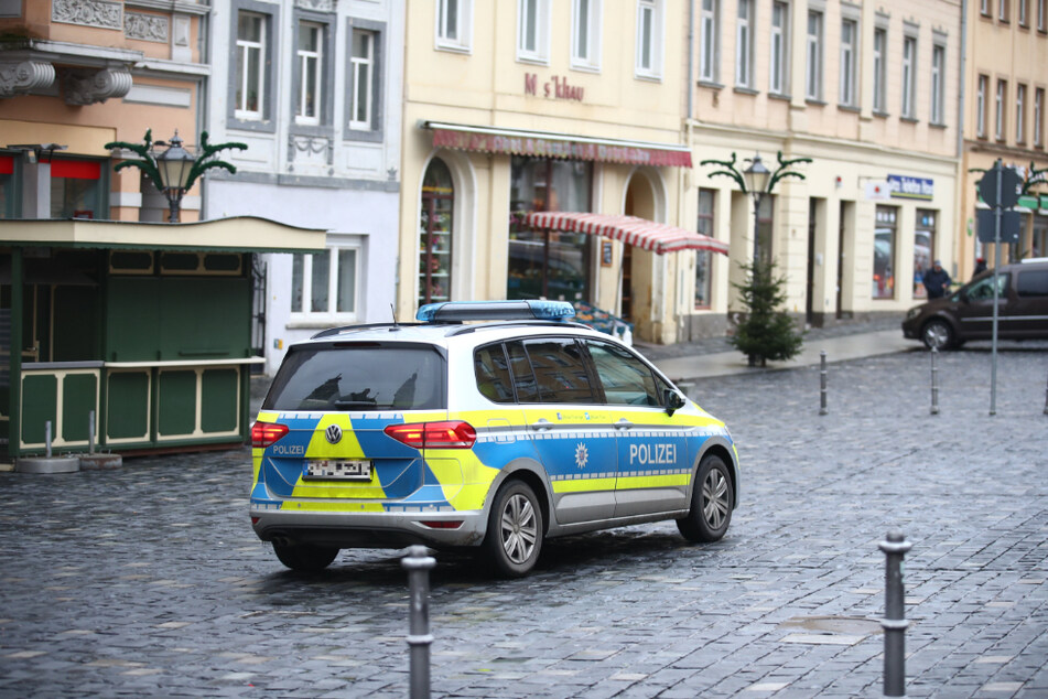 Ein Polizeifahrzeug fährt über den fast Menschenleeren Marktplatz im Zentrum der Stadt Altenburg. Mit einem Bewegungsradius von 15 Kilometern sollen die Infektionszahlen gesenkt werden.