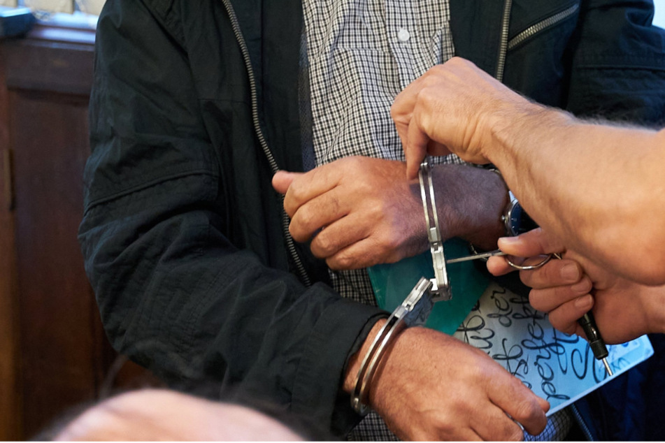 Dem 60-jährigen Angeklagten werden im Gerichtssaal des Oberlandesgerichts Koblenz die Handschellen abgenommen.