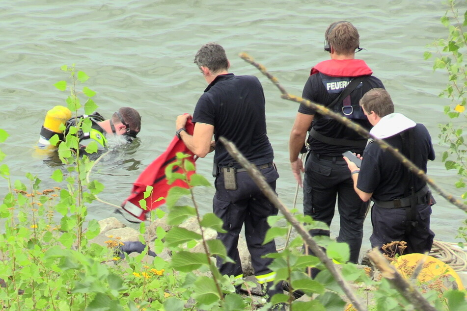 Helfer suchen im Rhein bei Düsseldorf nach einem Vermissten.