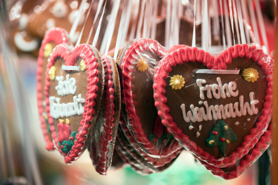 Lebkuchen-Herzen mit der Aufschrift "Frohe Weihnacht" hängen an einem Stand