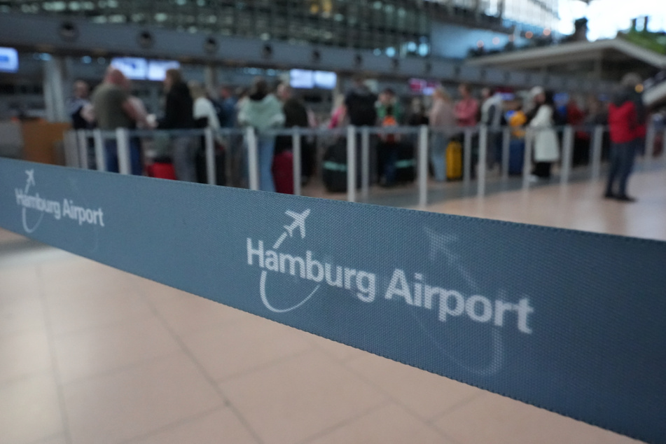 Flugpassagiere stehen an den Check-in-Schaltern in der Abflughalle des Hamburg Airports Schlange.