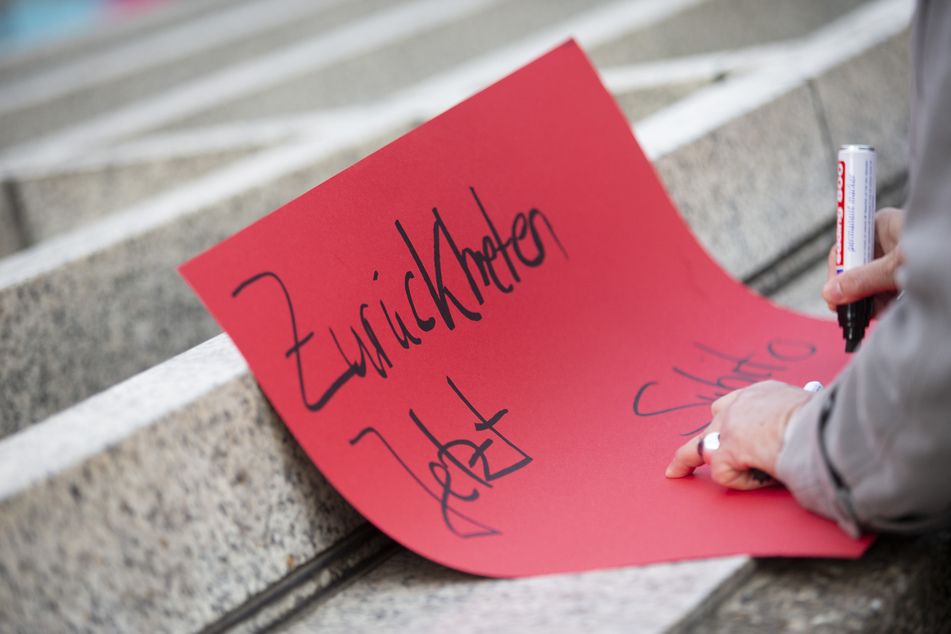 Die Reformbewegung "Wir sind Kirche" protestiert vor dem Kölner Dom gegen Kardinal Woelki.