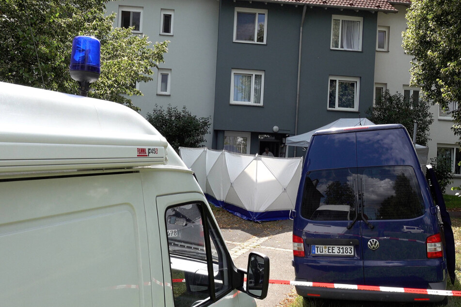 Einsatzfahrzeuge der Polizei stehen vor einer Wohnung in Reutlingen, in der mehrere tote Menschen gefunden wurden.