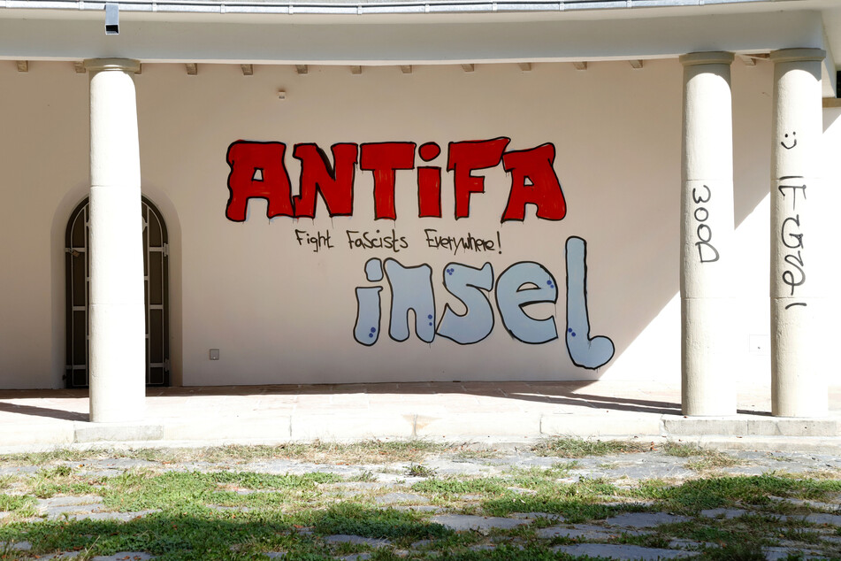 Auf der frischen Farbe prangt jetzt ein Schriftzug in Rot und Blau, auch der Steinsockel und die Rückseite sind beschmiert.