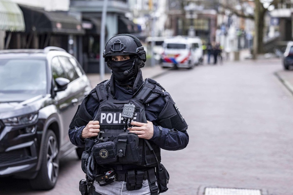 Ein Polizist einer niederländischen Spezialeinheit sichert den Bereich um den Tatort ab. Bei einer unblutig beendeten Geiselnahme sind vier Menschen von einem polizeibekannten Täter mit Messern bedroht worden.