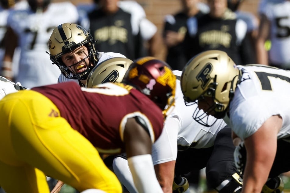 Aidan O'Connell of the Purdue Boilermakers calls the play at the line of scrimmage against the Minnesota Golden Gophers.
