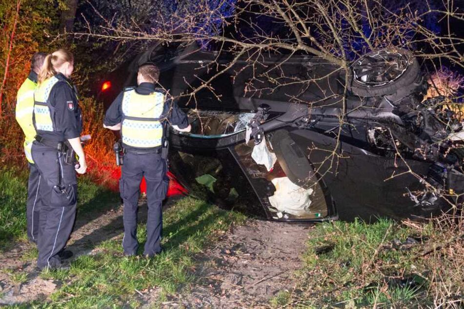 Polizeibeamte stehen neben dem verunglückten Mercedes.