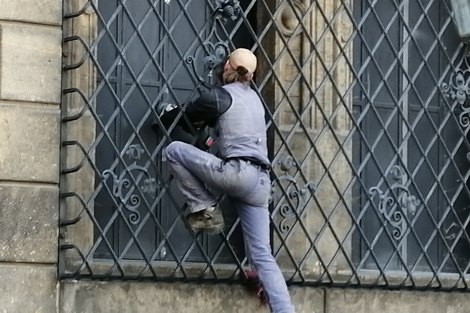 Ein Handwerker bearbeitet die frisch verschraubten Fensterläden am Historischen Grünen Gewölbe mit einer Schleifmaschine.