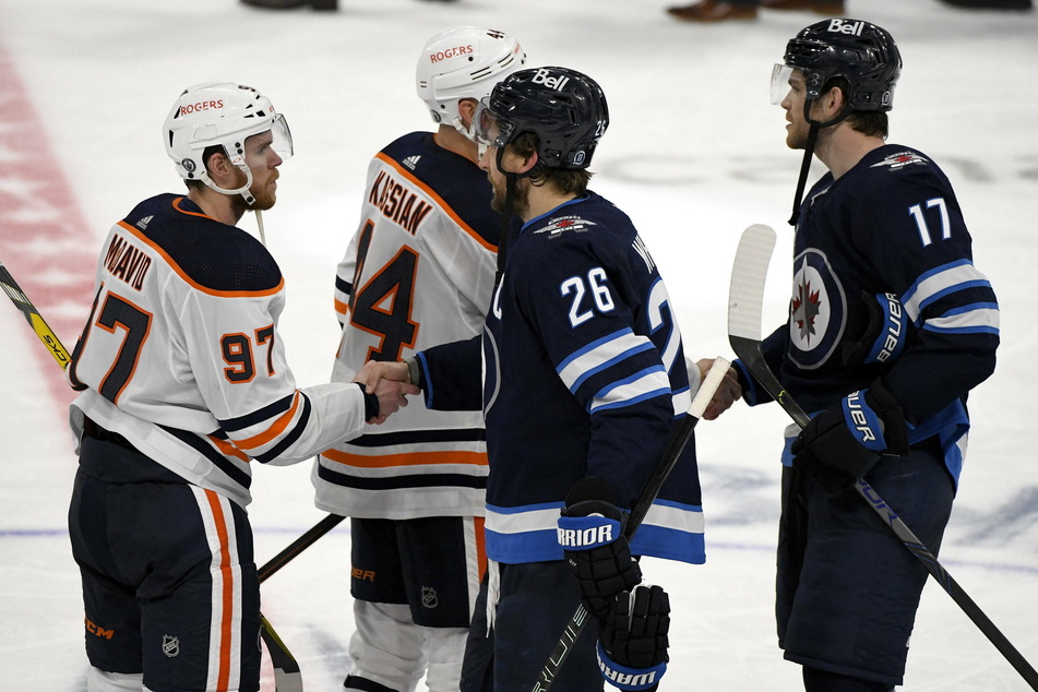 Jets captain Blake Wheeler (c) shakes hands with Connor McDavid (l) to close out the series sweep in Edmonton