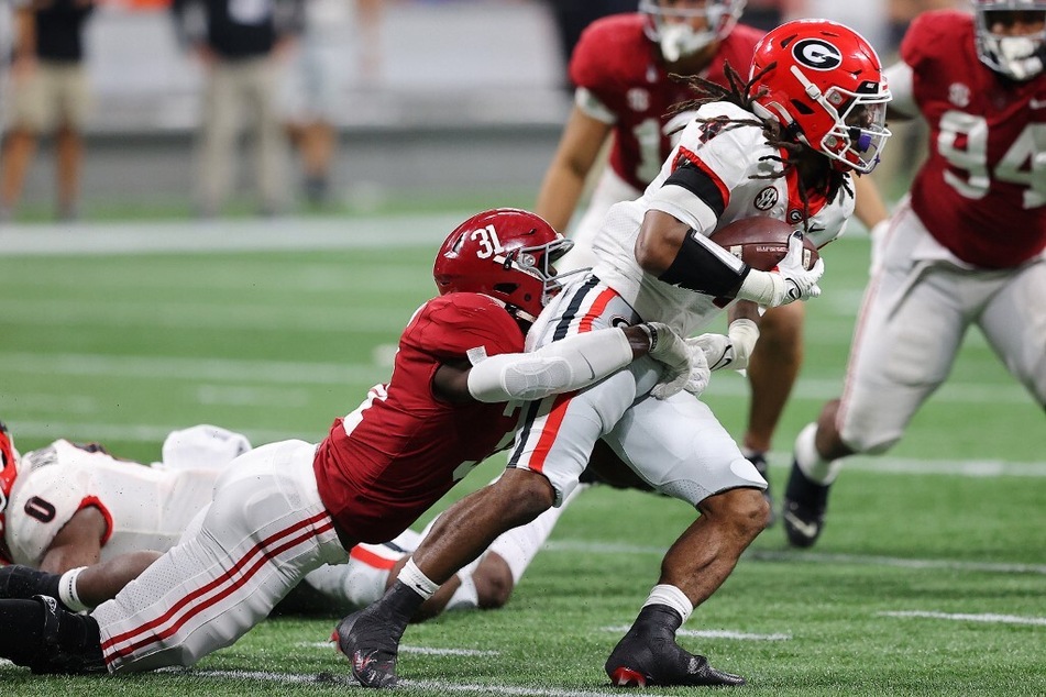Will Anderson Jr. of the Alabama Crimson Tide tackles James Cook of the Georgia Bulldogs during the third quarter of the SEC Championship game.