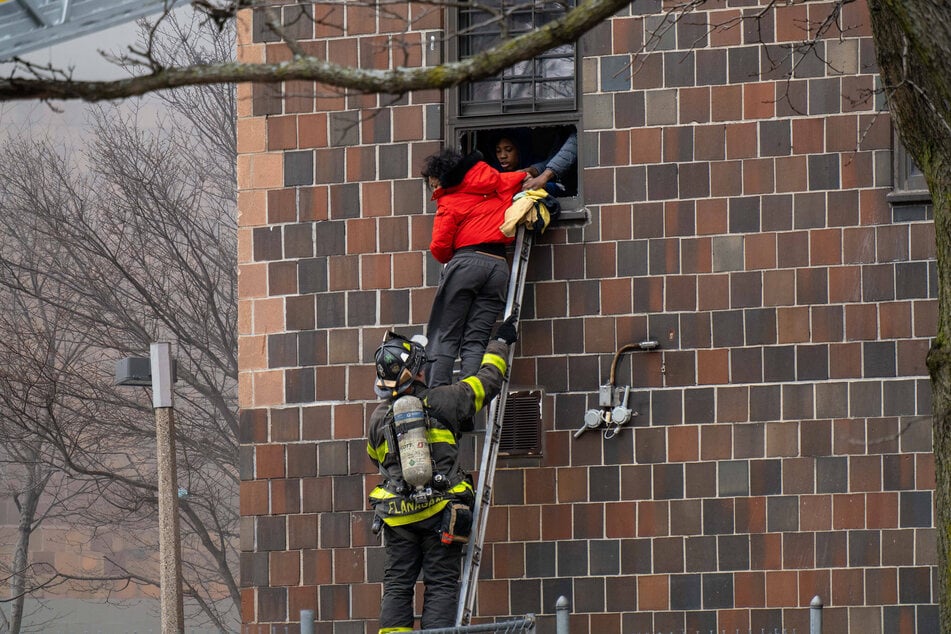 Firefighters rescued people by ladder through their windows after a fire broke out inside a third-floor duplex apartment on Sunday.