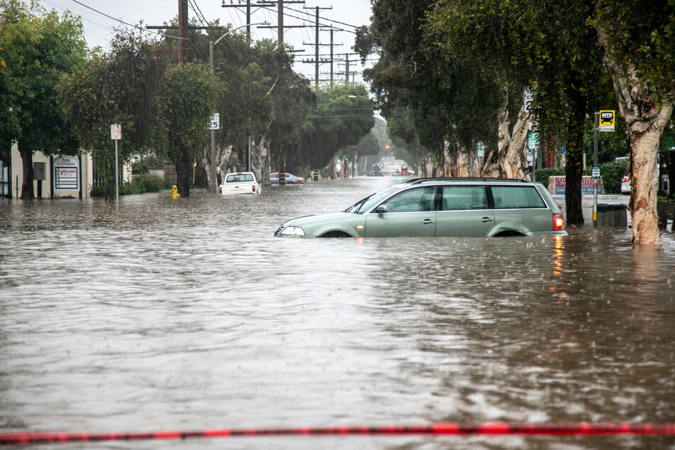 Abandoned cars are left in a flooded street in east Santa Barbara, California.