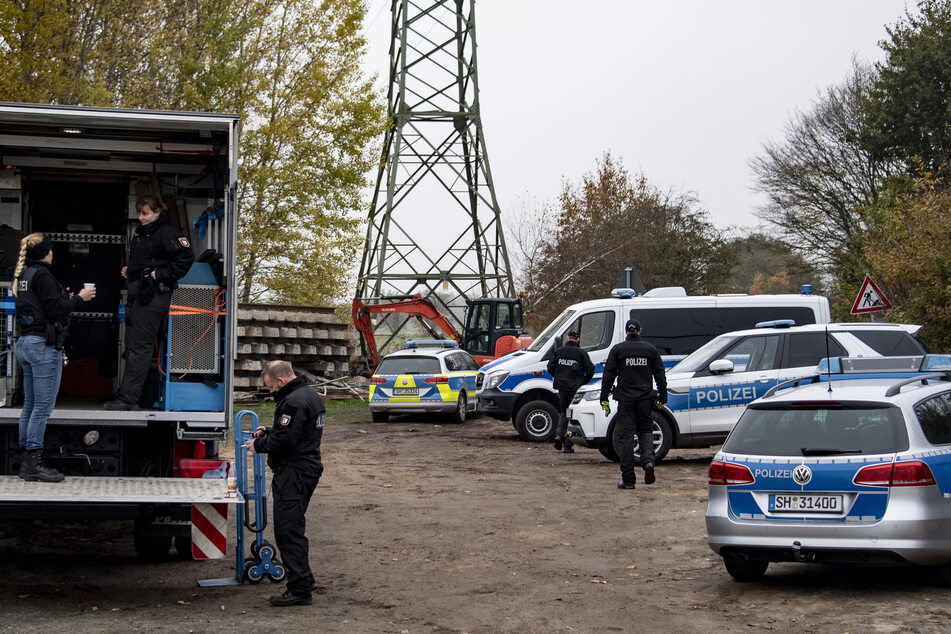 Polizeifahrzeuge stehen in der Nähe der Kleingartenanlage.